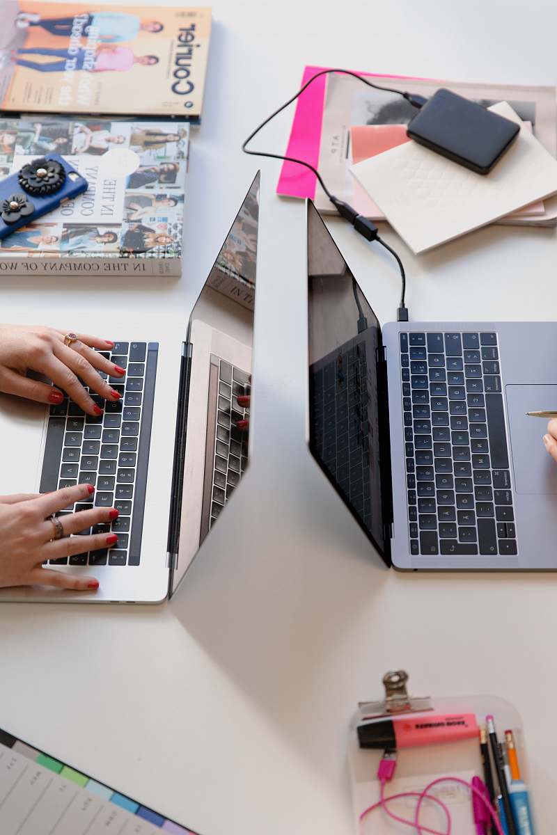 paper person typing on silver laptop computer office