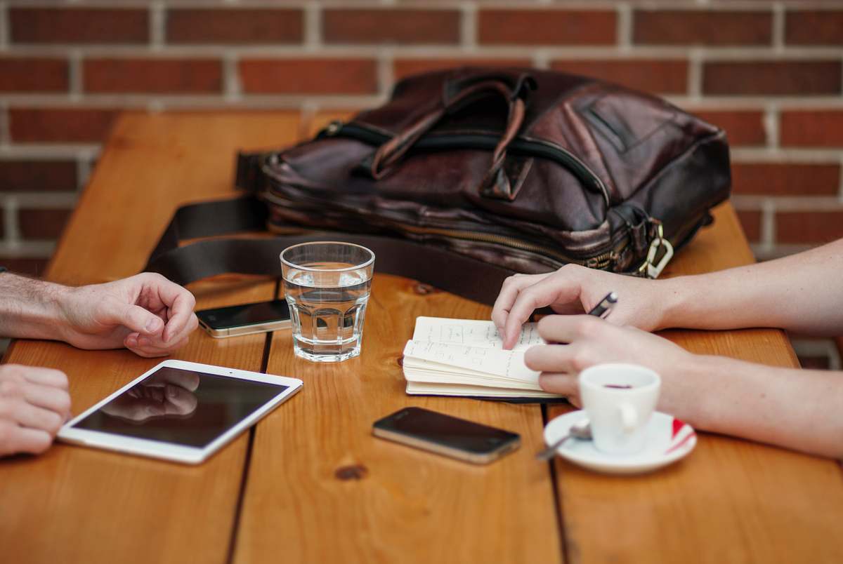 meet two person sitting in front of table cafe