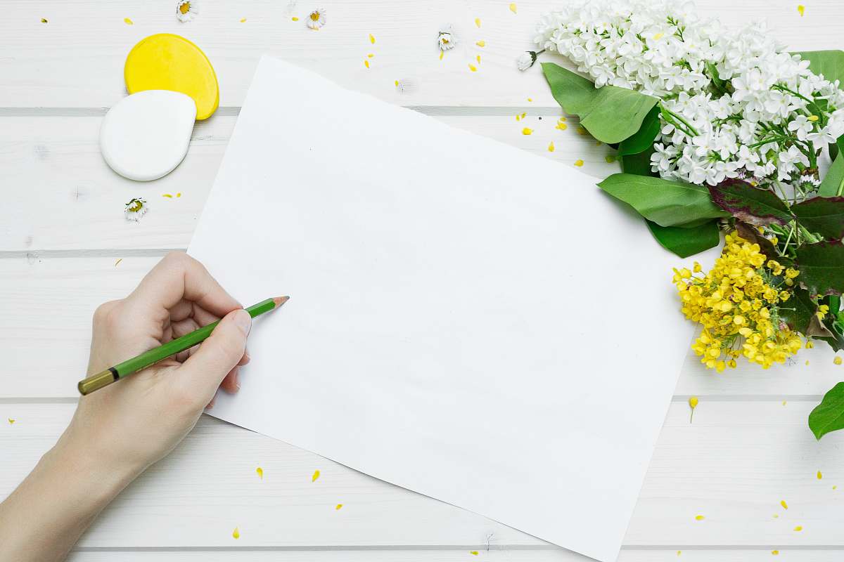 flower person about to write on white printer paperr paper