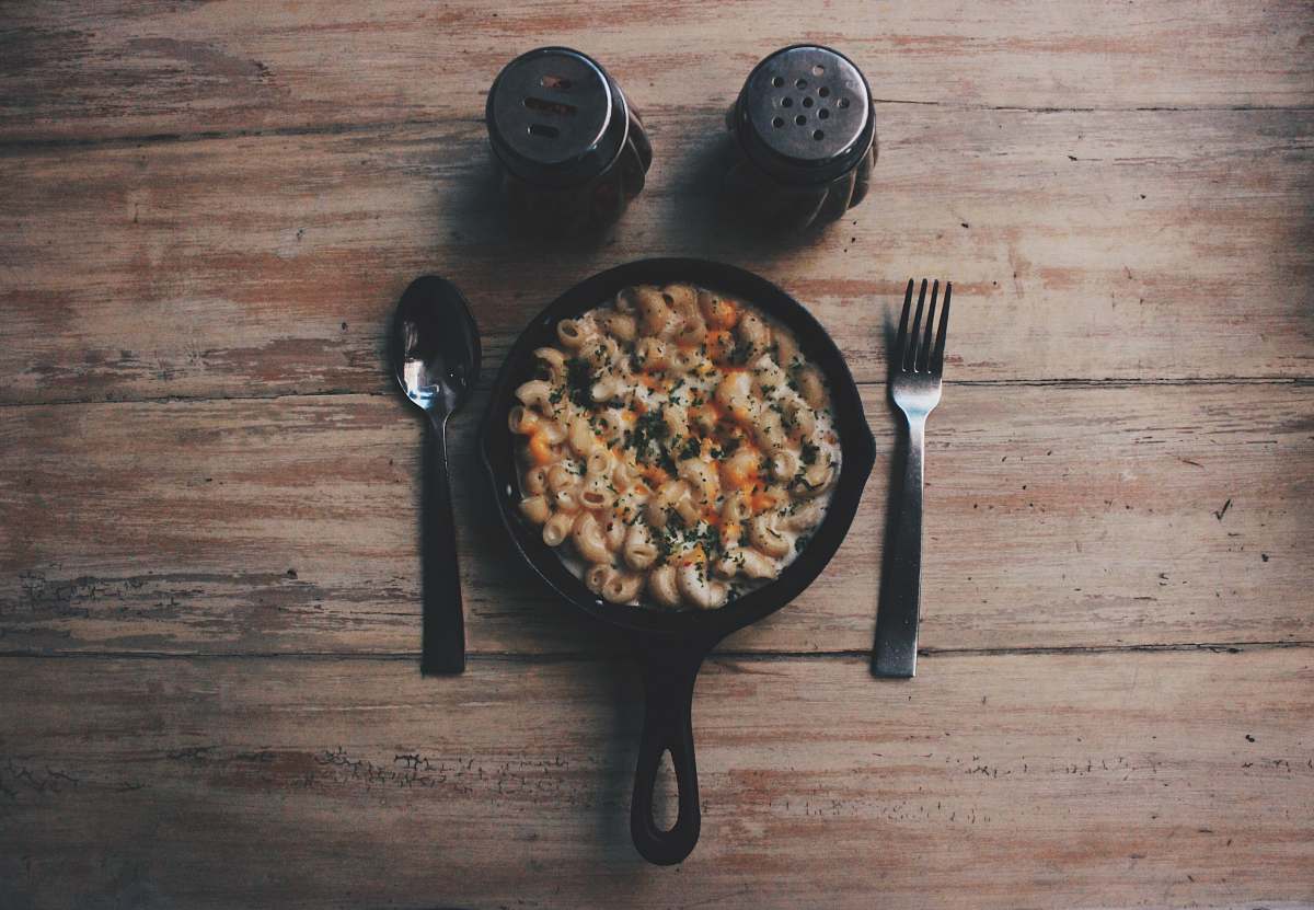  cooked food on black plate beside fork and spoon on brown wooden table 