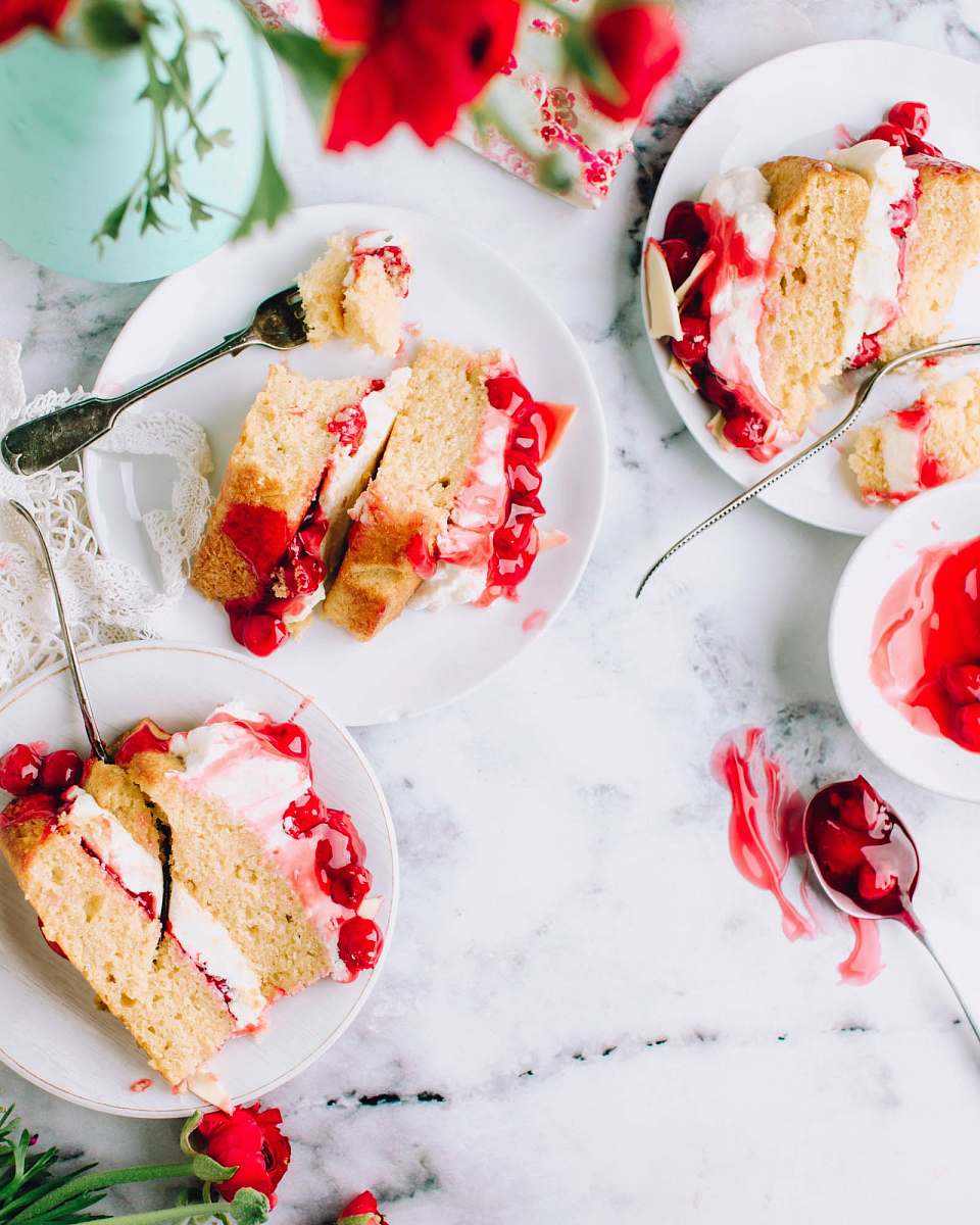  sliced cakes beside stainless steel forks on round white ceramic plates 