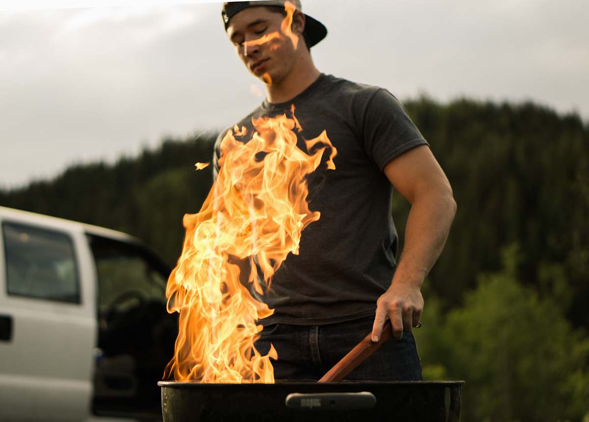 flame man grilling near white vehicle fire