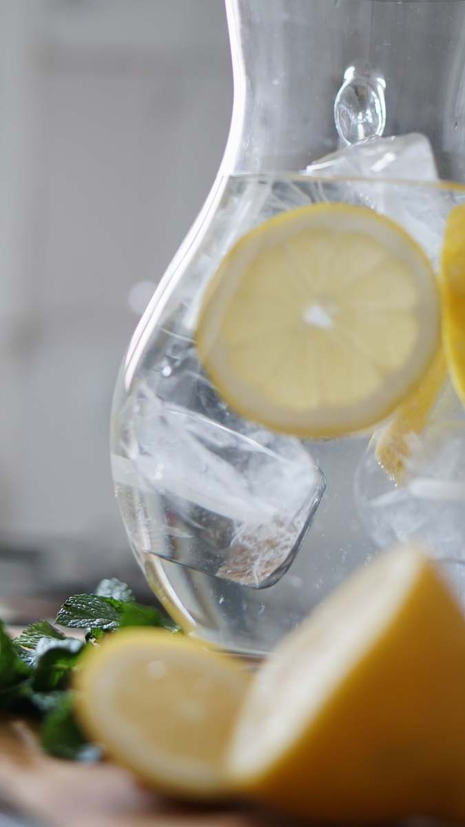 lemonade sliced lemon inside pitcher with ice cubes drink