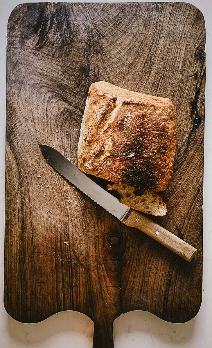 knife bread beside knife on chopping board weapon