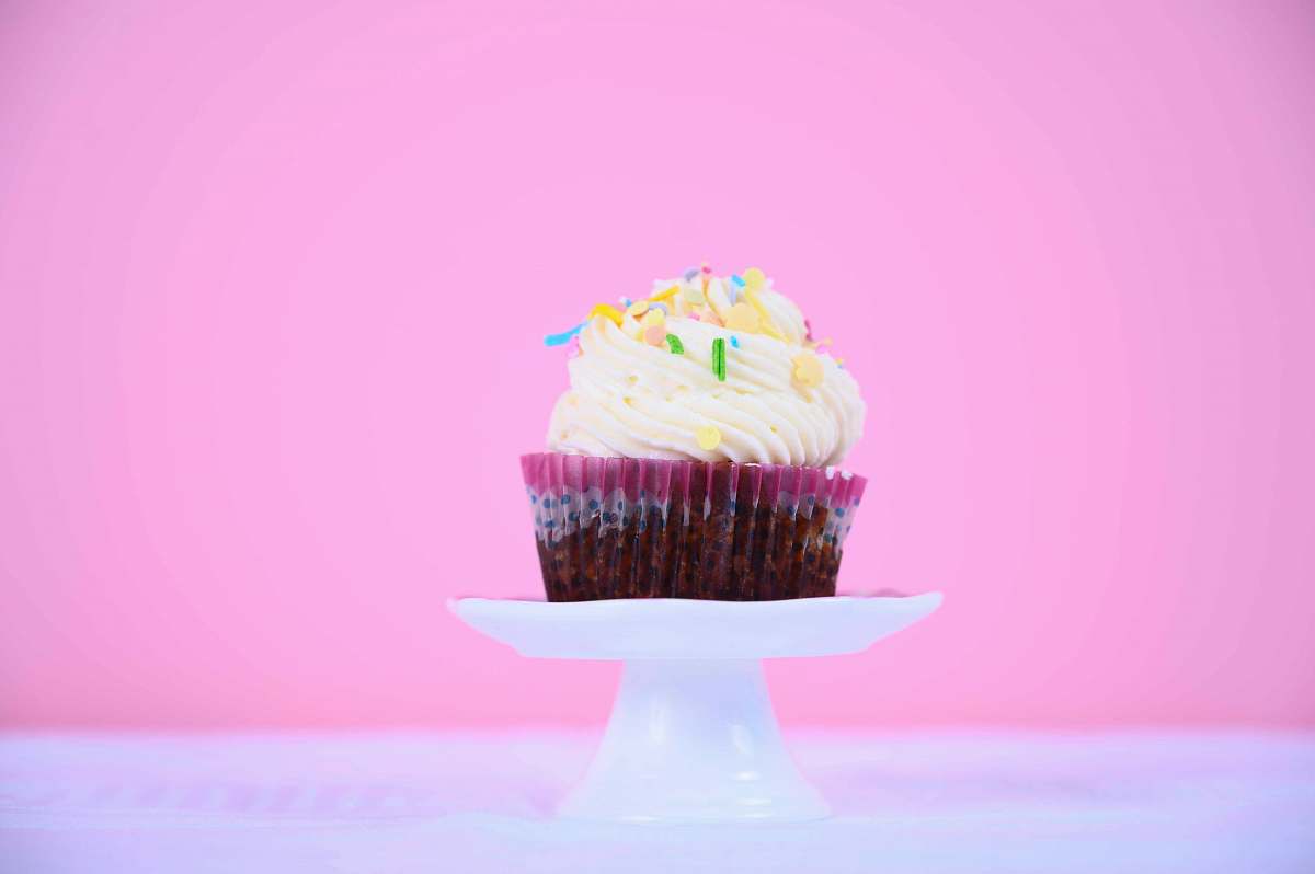 cream cupcake on white footed tray creme