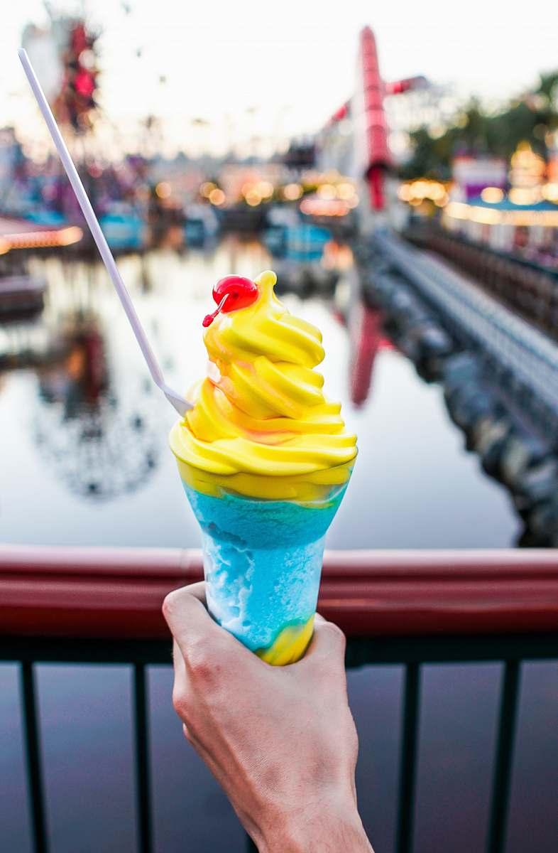 creme person holding a blue cone yellow ice-cream close-up photography dessert