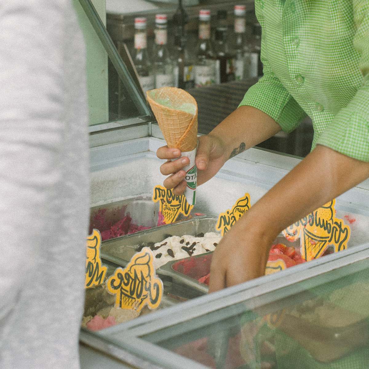 creme person holding ice cream cone and scooping ice cream in deep freezer cream