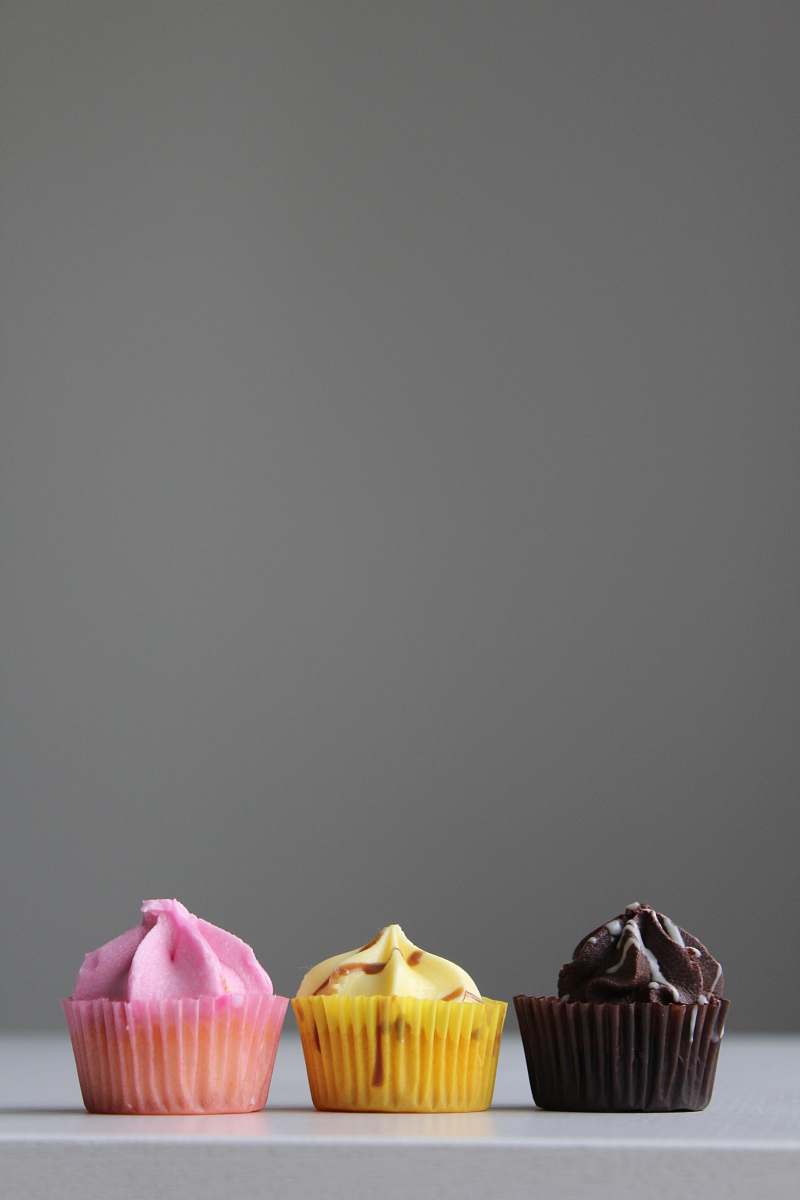 icing three cupcakes on white surface creme