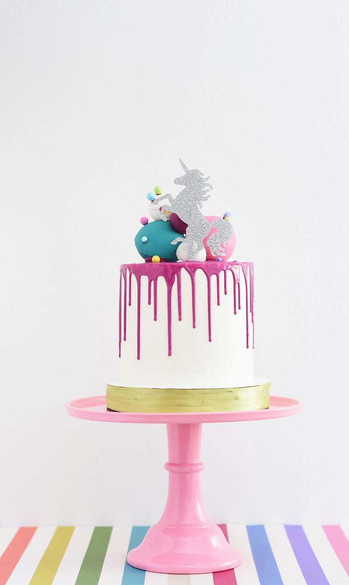 food white and pink unicorn cake on a pink stand cake