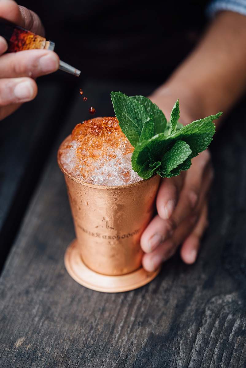 mint brass-colored cup filled with crushed ice with mint beverage
