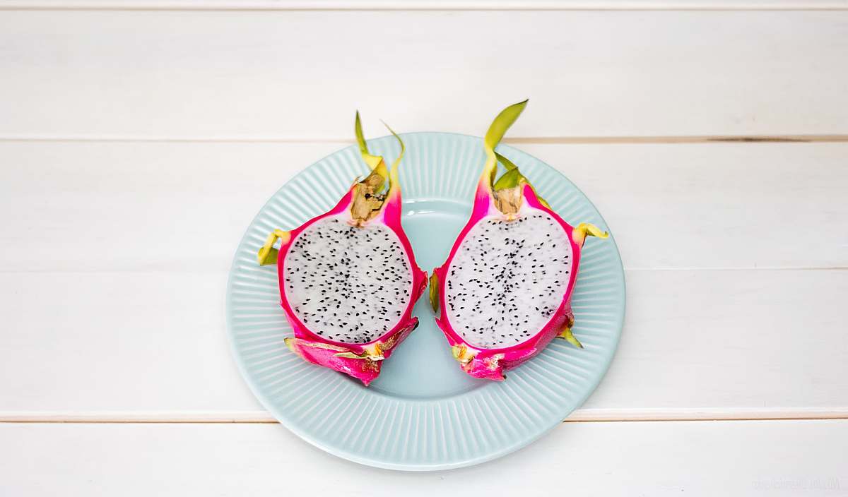 fruit 2-sliced dragon fruit in ceramic plate placed on wood plank dragon fruit
