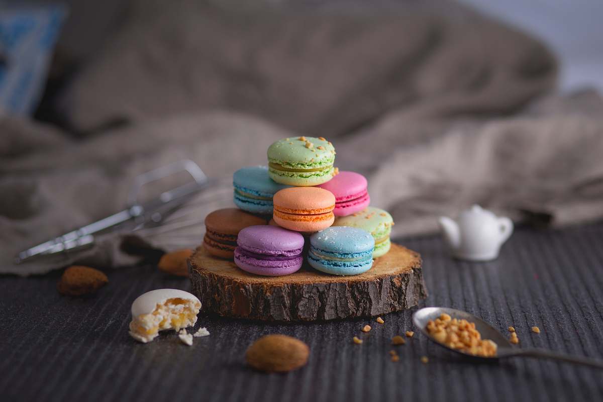 dessert assorted-color macaroons on wood slab cream