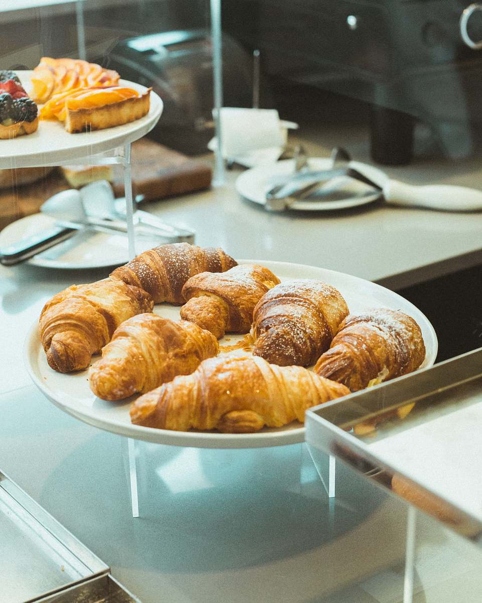 bread baked bread placed on round white ceramic plate croissant