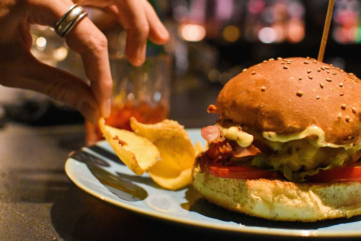 burger burger beside chips on plate human