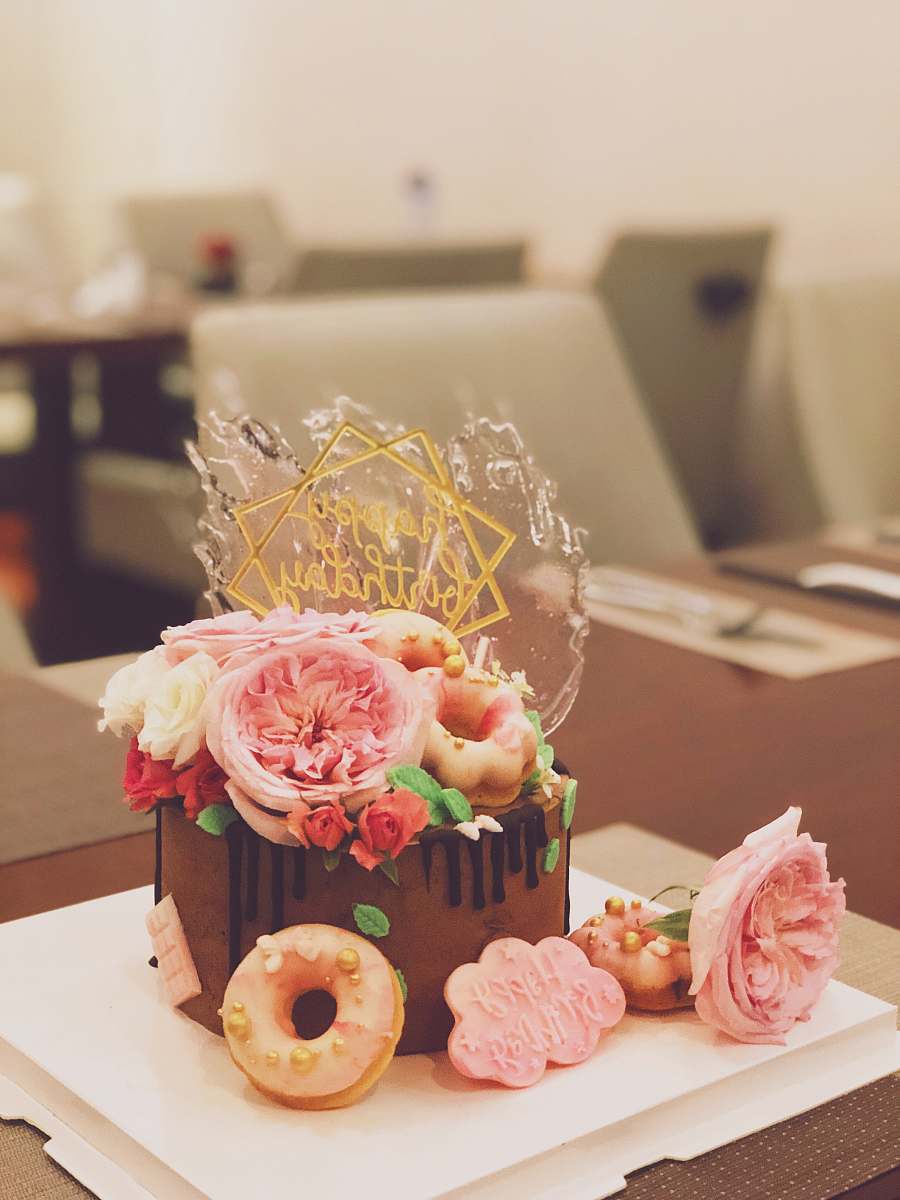 cake chocolate cake topped with roses and doughnuts creme