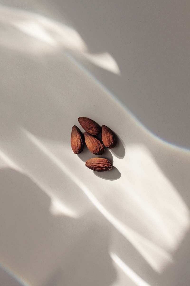 nut close-up of almond nuts on white surface bean