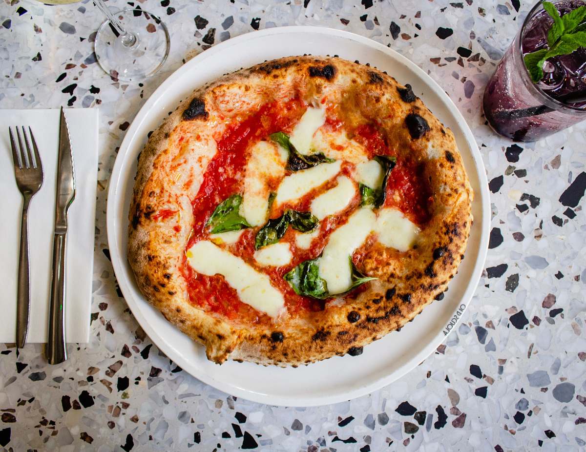 pizza cooked food on round white ceramic plate fork