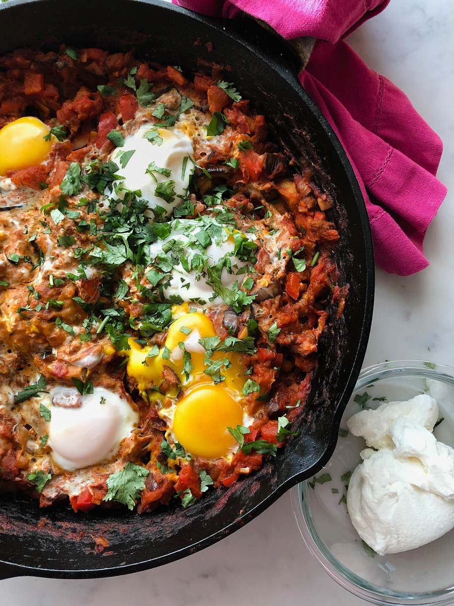 bowl cooked meat with eggs in skillet shakshuka