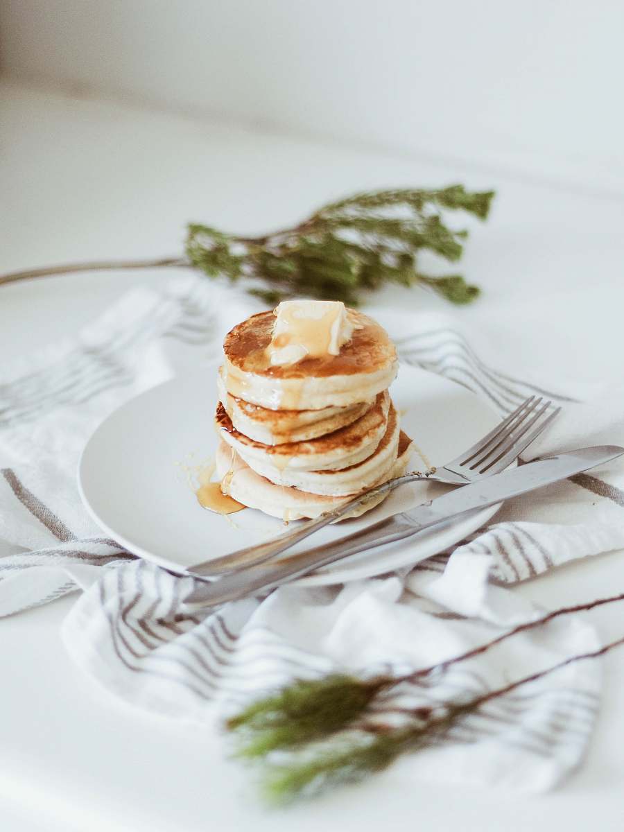 pancake cooked pancake on round white ceramic plate beside butter knife and fork plate