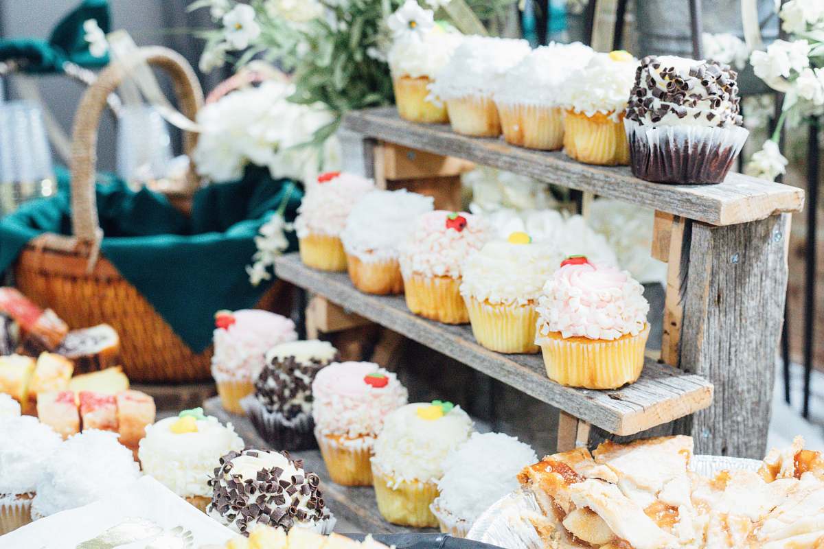 creme cupcakes on wooden stand beside basket cream
