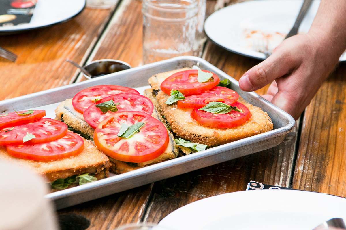 hand deef fried vegetables being served on a gray steel pan dish