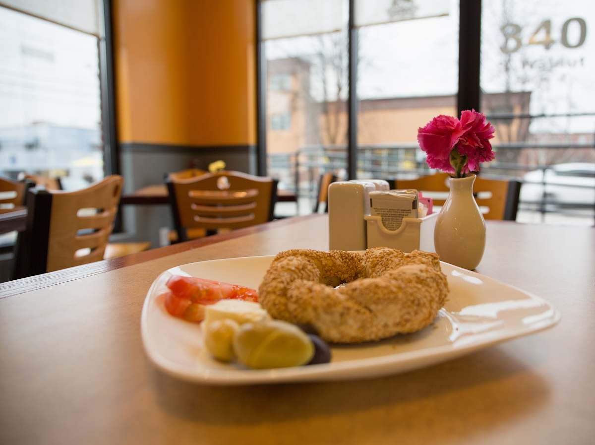 breakfast doughnut on white ceramic saucer on table flower