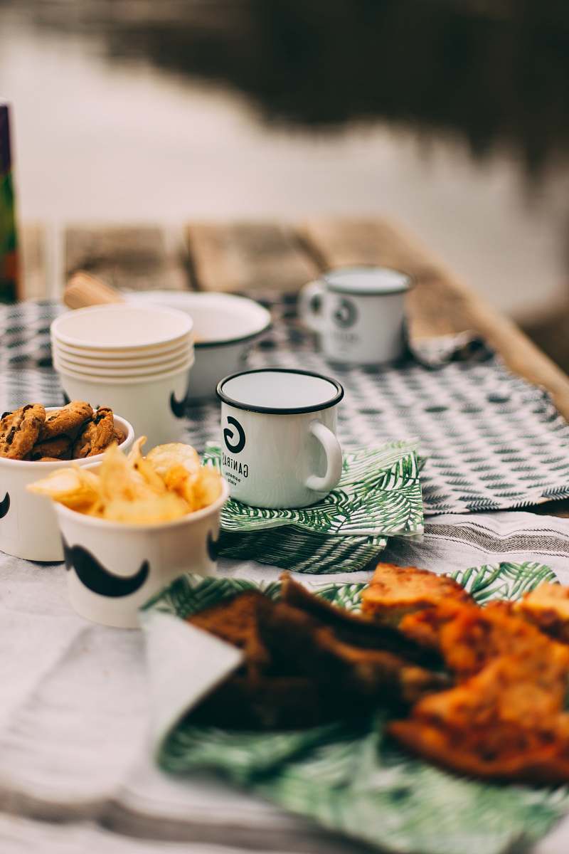 meal enamel-coated mugs and plastic cups on table selective focus photography breakfast