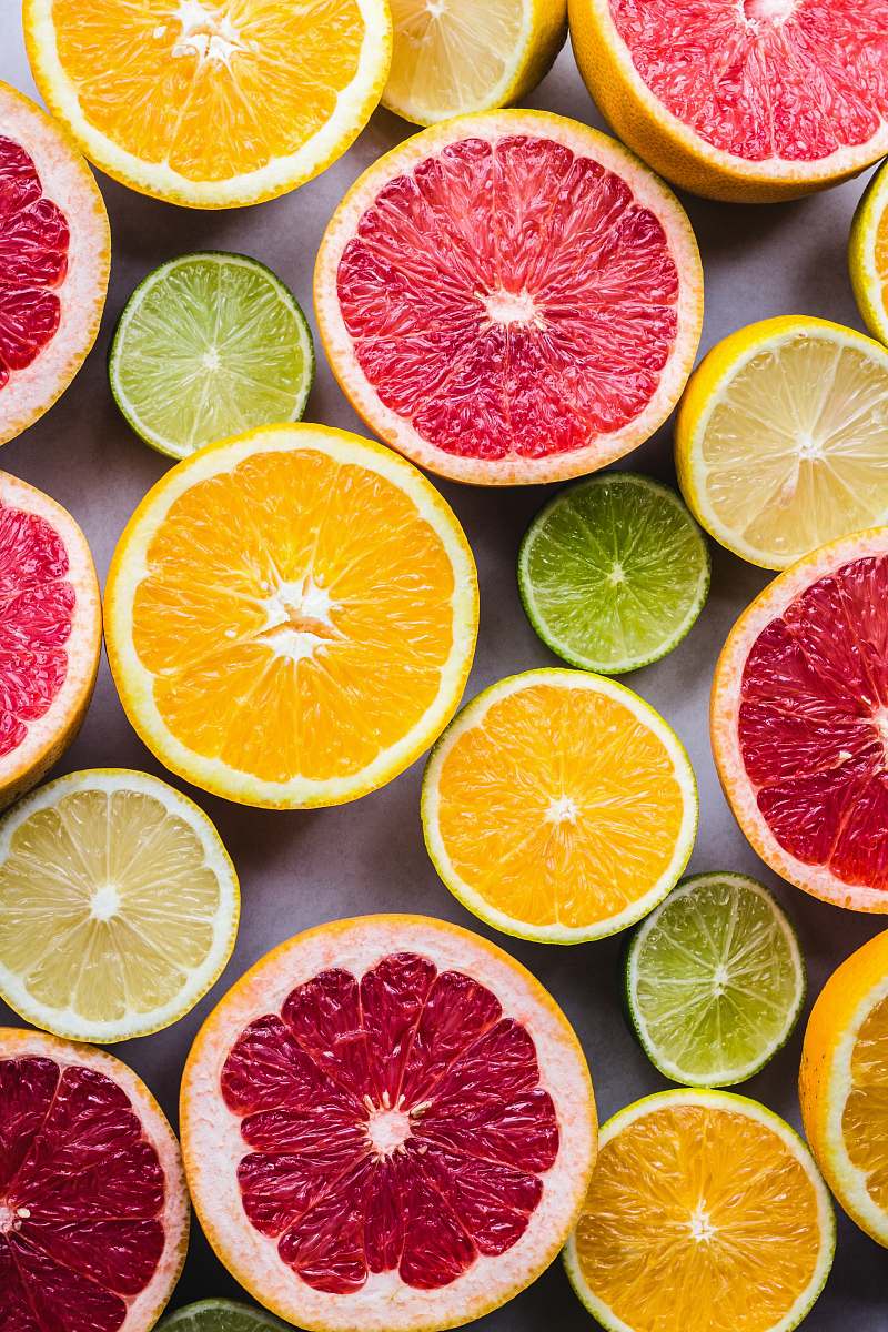 fruit flat lay photography of sliced pomegranate, lime, and lemon citrus fruit