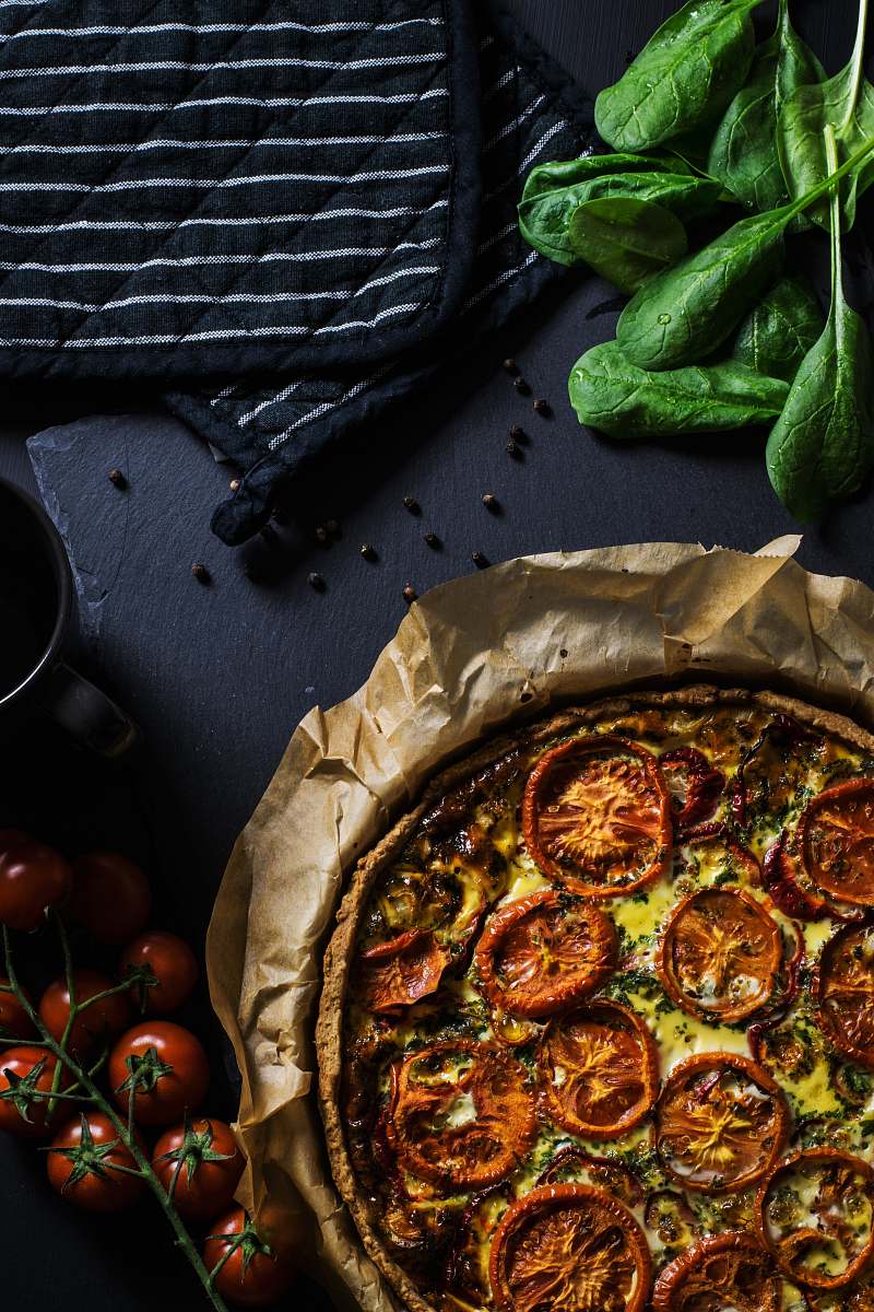 vegetable flat lay photography of two black pot holders beside tomatoes and pizza tomato