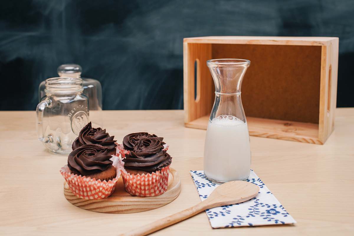cake four cupcakes on brown coaster and milk jar cupcake