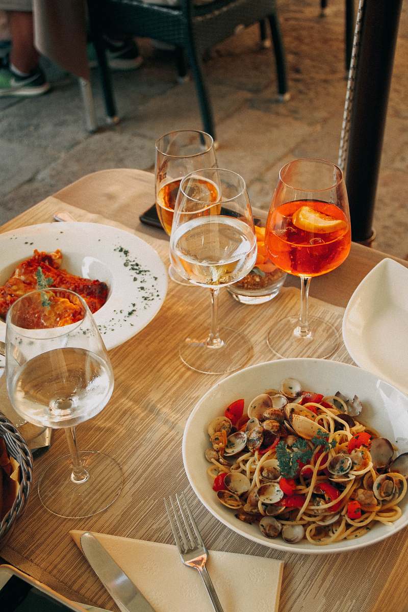 bowl four filled wine glasses and foods on table dinner