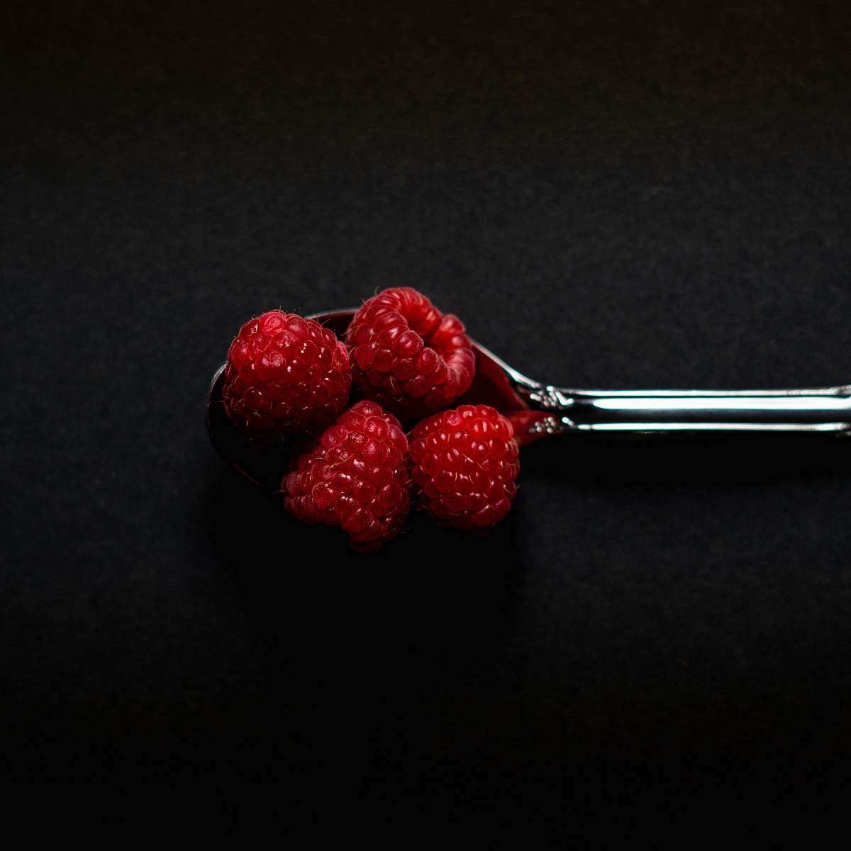 plant four Strawberry fruits on stainless steel spoon fruit