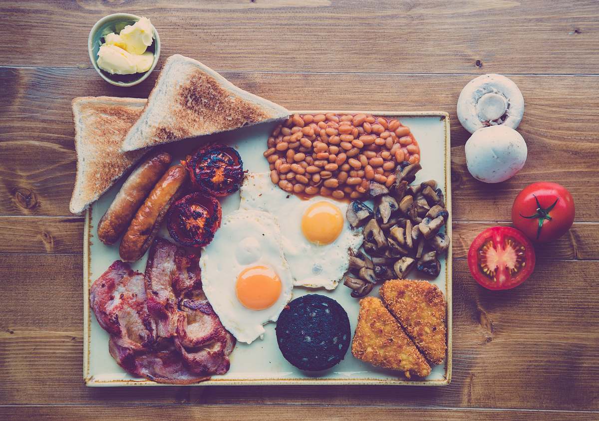 breakfast fried ham, egg, bread with beans and red tomato slice meal