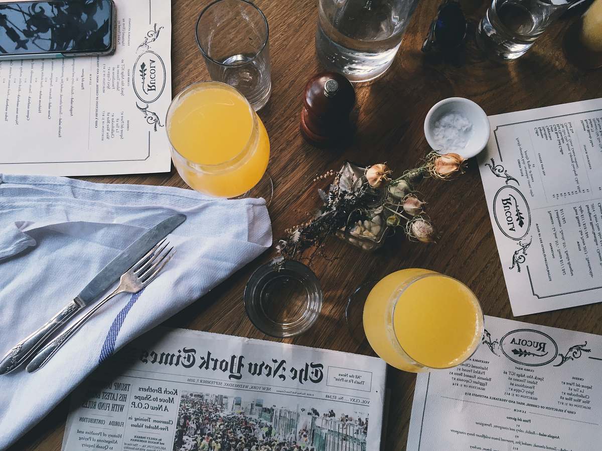 drink grey New York Time newspaper on table together with juice glasses restaurant