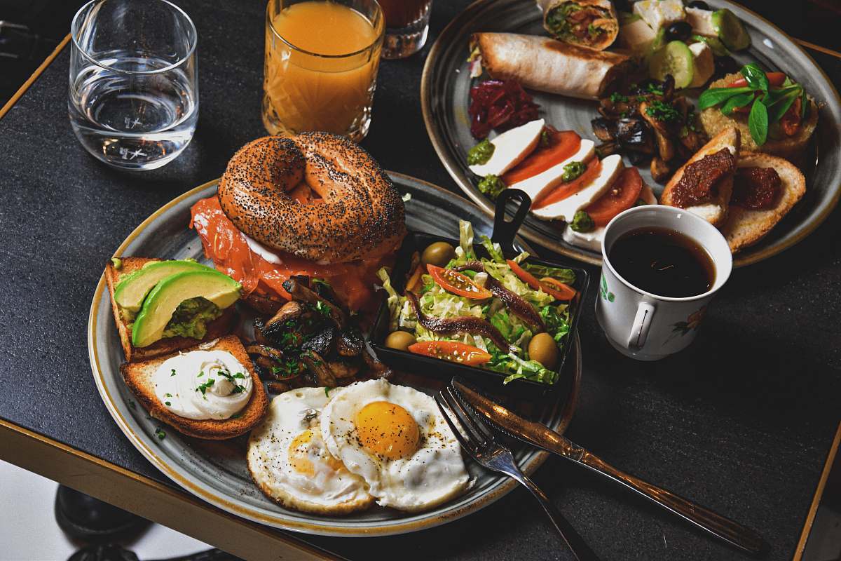 bread hamburger, fried eggs, avocado slices, and bread on round gray plate burger