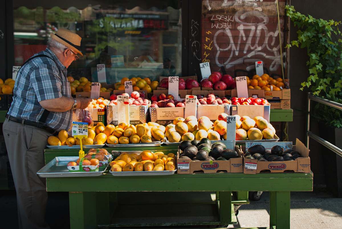 fruit man picking fruit from a fruit stand citrus fruit