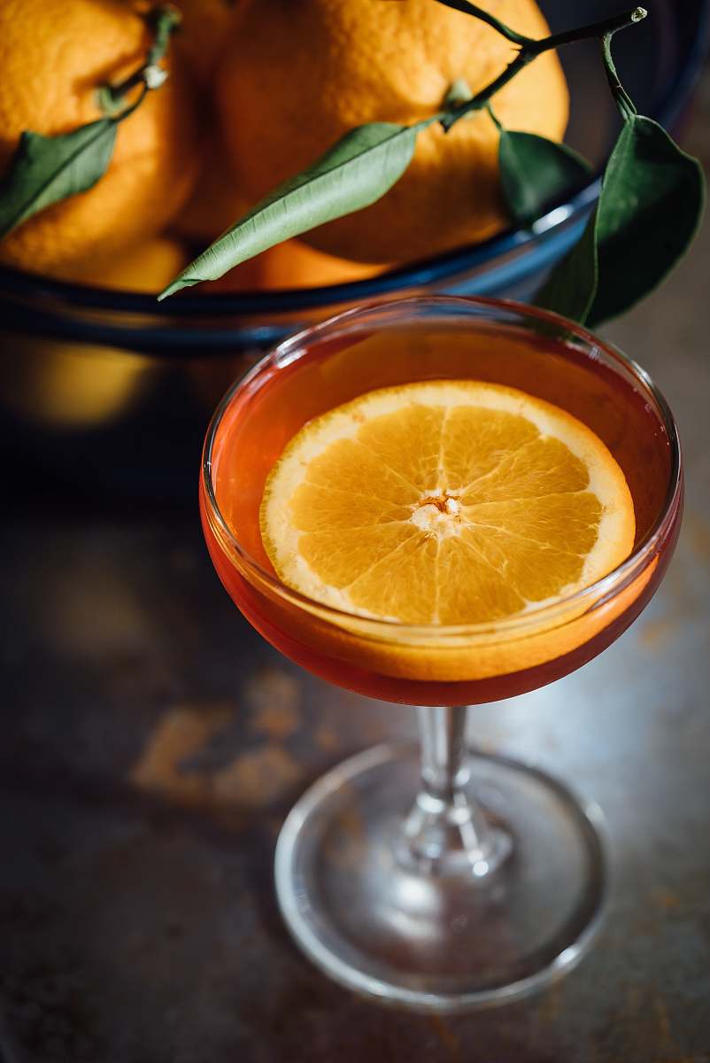 drink orange slice in a wine glass full of orange liquid cocktail
