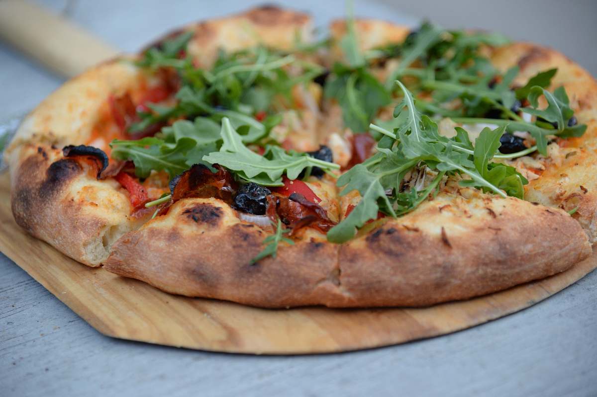 pizza pepperoni pizza with green leafed toppings tray