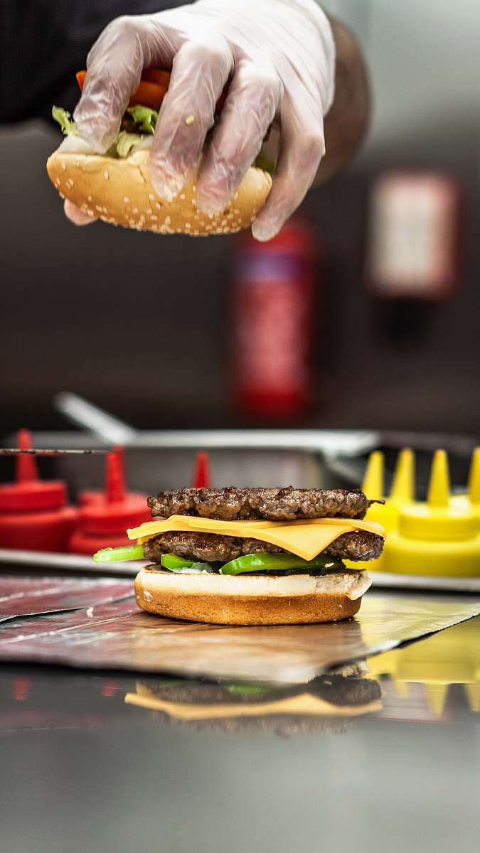 burger person assembling cheese and patty burger human