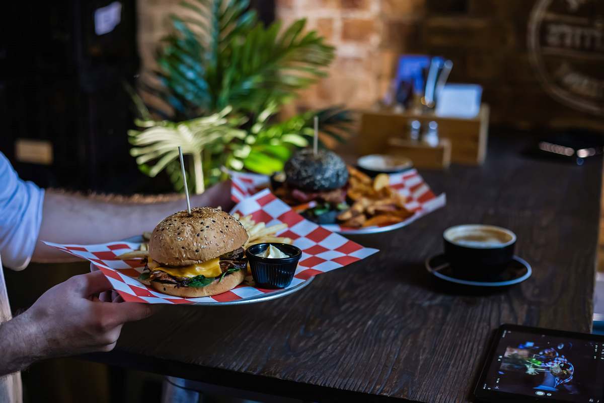 burger person holding cheese burger on plate furniture