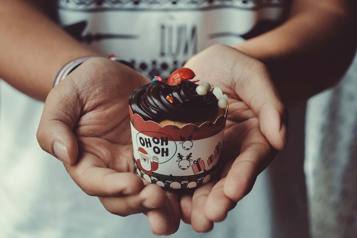 confectionery person holding chocolate cake sweets