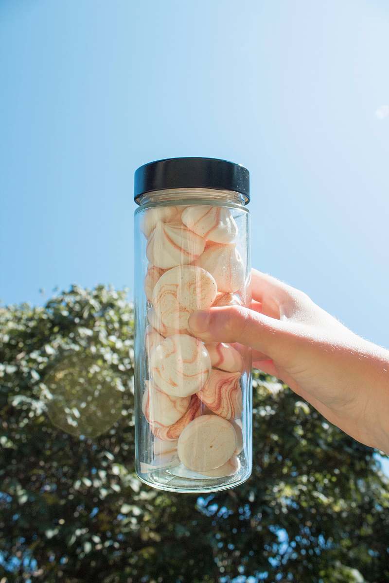 confectionery person holding clear glass container sweets