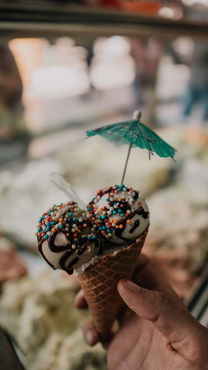 confectionery person holding ice cream cone sweets