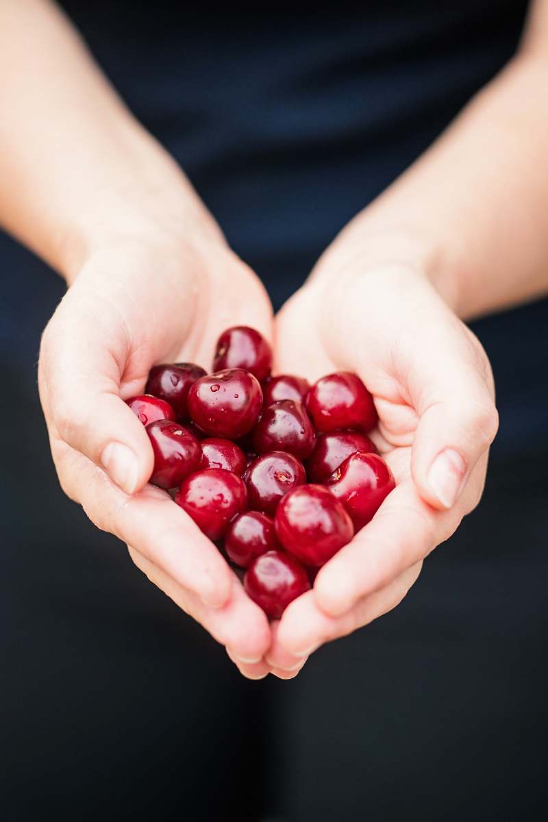 heart person holding red cherries person