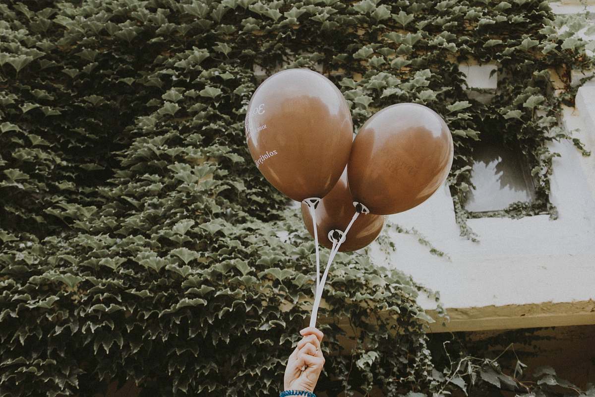 egg person holding three balloons ball