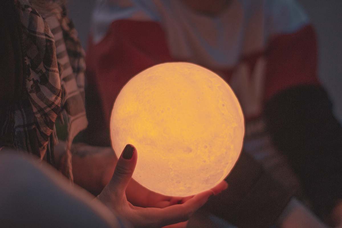 egg person holds lighted ball sphere