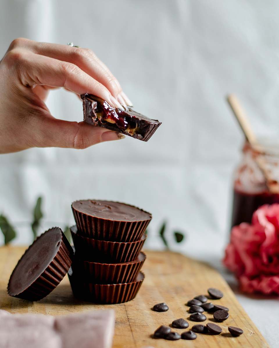 confectionery person piling cupcakes on chopping boad sweets