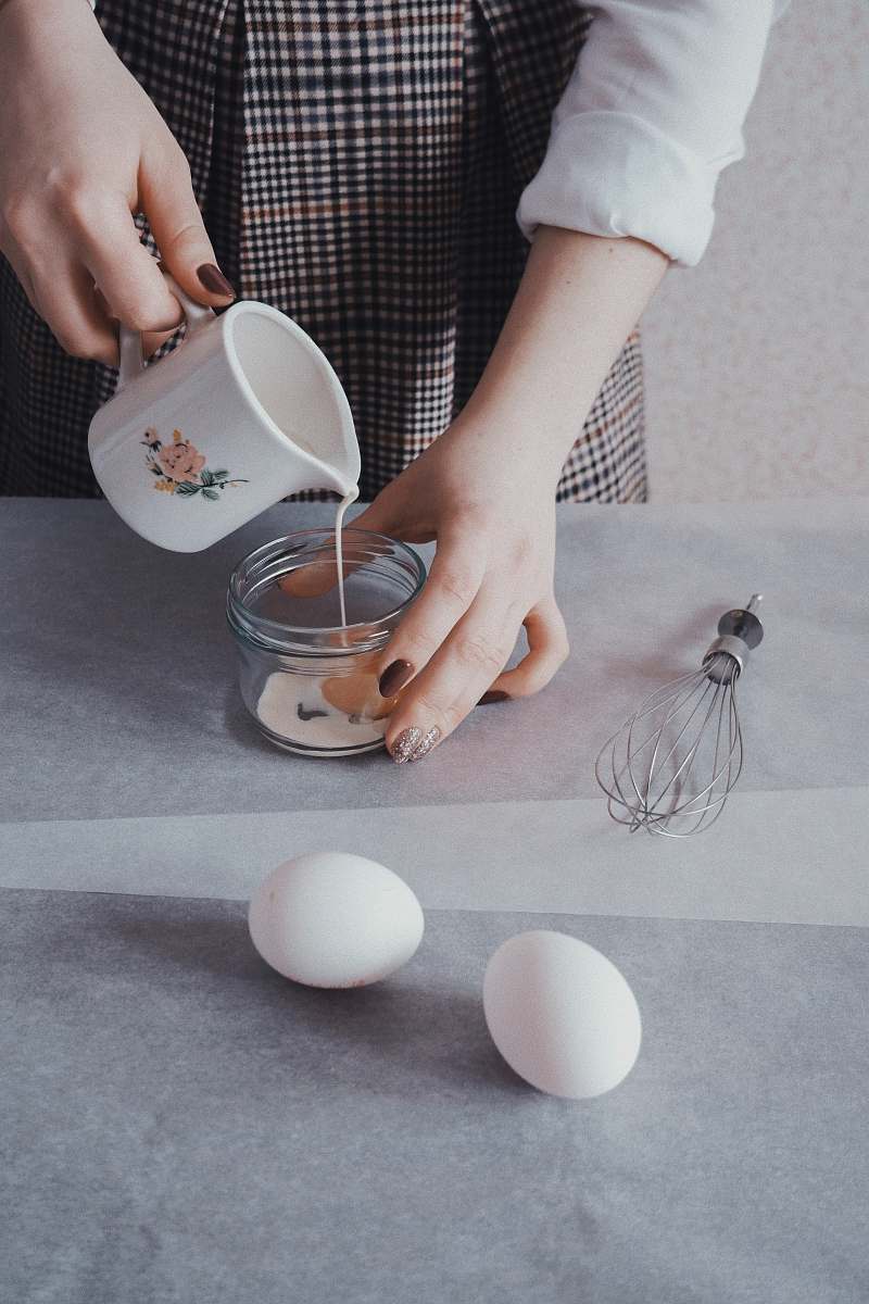 egg person pouring white liquid in jar person