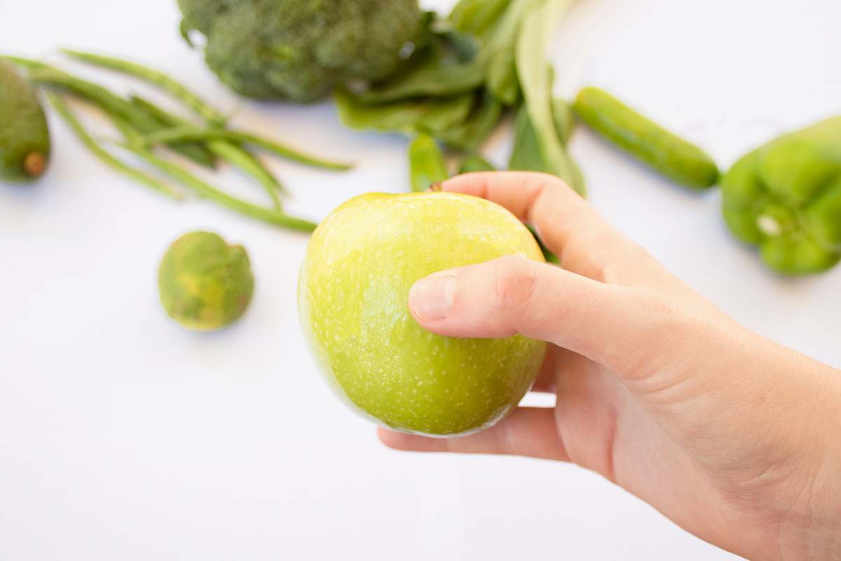 flora person's hand holding green apple pea