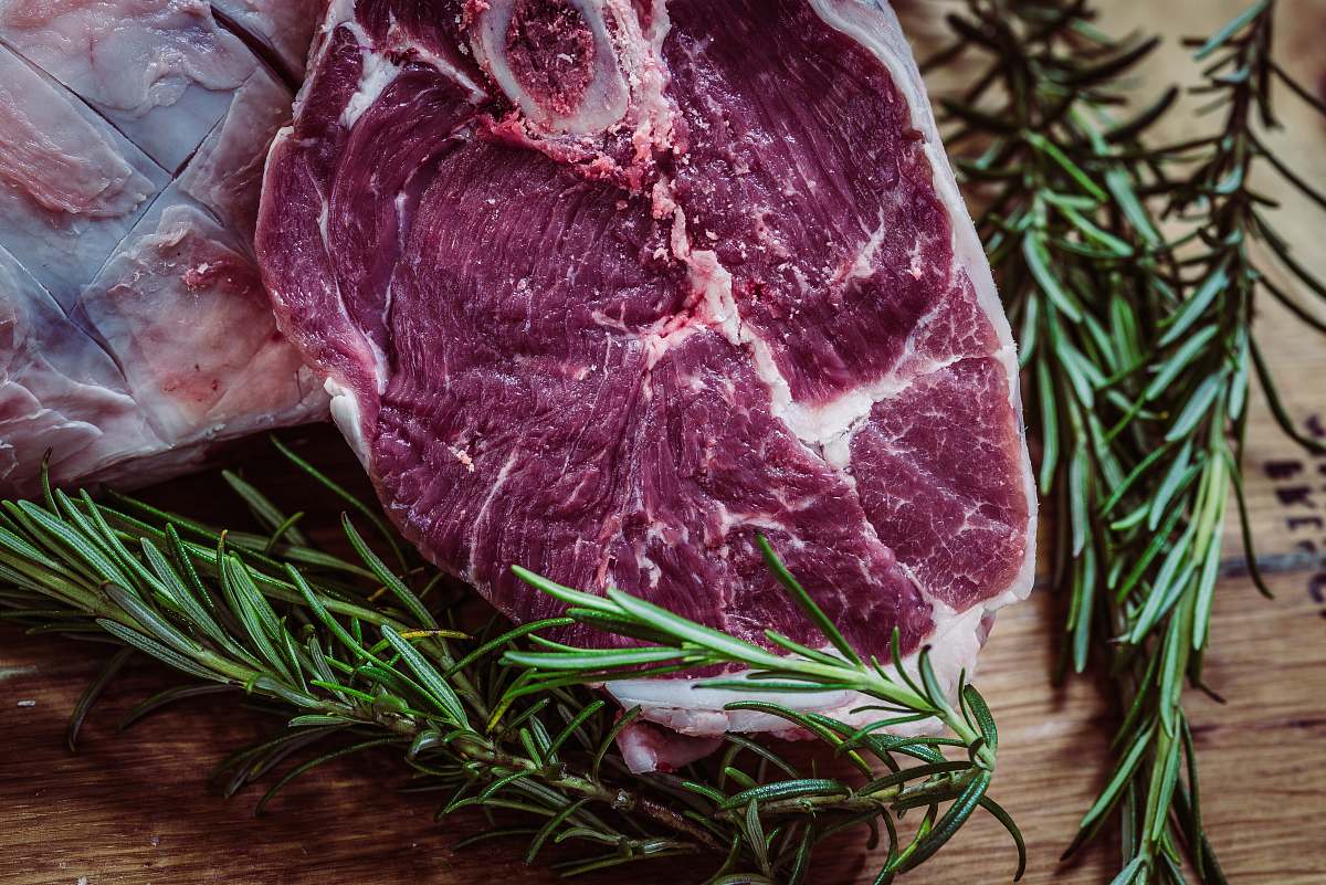 meat raw meat and green leaf plant on brown surface rosemary